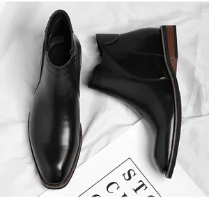 Detailed view of polished black leather men's Chelsea boots featuring side zipper closure