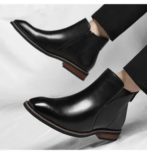 Close-up of black men's Chelsea boots featuring a side zipper and polished finish