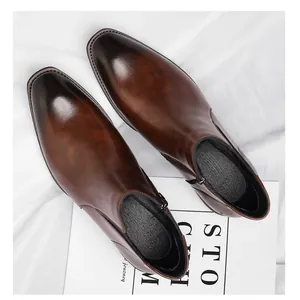Top-down view of men's brown burnished leather Chelsea boots with side zippers.