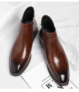 Macro detail of brown men's Chelsea boots featuring side zipper and gradient finish
