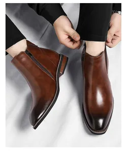 Detailed macro view of brown leather Chelsea boots with side zipper and polished finish