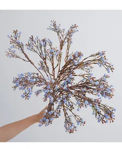Detailaufnahme des künstlichen blauen Wachsblumenstrauchs mit feinen Knospen und Zweigen.