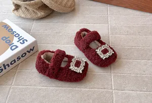 Detailansicht der weinroten flauschigen Mädchenschuhe mit glitzernder Strassschnalle.
