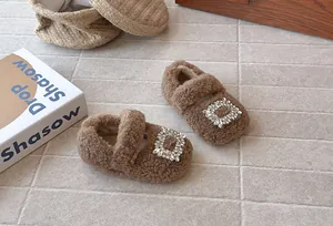 Nahaufnahme brauner pelziger Mädchen-Prinzessinenschuhe mit funkelnder Strassschnalle.