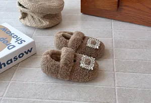 Detailansicht brauner Plüsch-Babyschuhe mit funkelnder Strassschnalle für Winter.