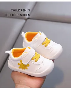 Close-up view of breathable white toddler shoes with yellow sun pattern detail and velcro strap