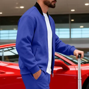 Hombre con chaqueta deportiva azul y pantalones a juego junto a un coche deportivo rojo