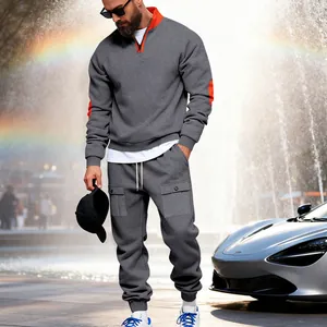 Man posing outdoors wearing a grey heavyweight fleece tracksuit with orange details.
