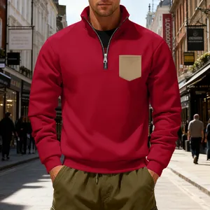 Detail view of men's red half-zip fleece sweatshirt with contrast beige chest pocket.