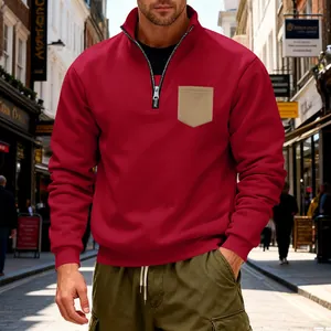 Close-up of men's red quarter-zip sweatshirt with a beige chest pocket detail.
