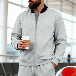 Detalle de chaqueta gris para hombre con cremallera, cuello levantado y puños elásticos.