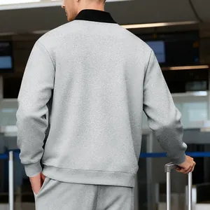 Vista trasera de un conjunto de chaqueta gris con cuello alto para hombre en aeropuerto