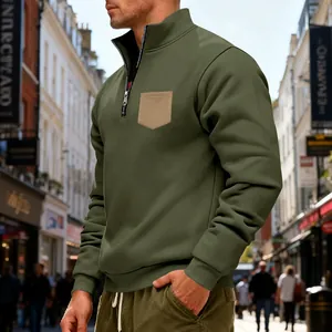 Olive green quarter-zip sweatshirt for men featuring a contrast chest pocket in urban setting