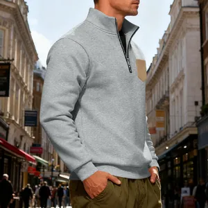 Close-up of a grey men's heavyweight fleece quarter-zip hoodie with khaki chest pocket