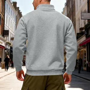 Back view of a men's heavyweight gray quarter-zip fleece sweatshirt in a street setting