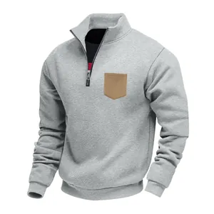 Detailed view of grey heavy fleece men's sweatshirt with quarter zip and tan chest pocket.