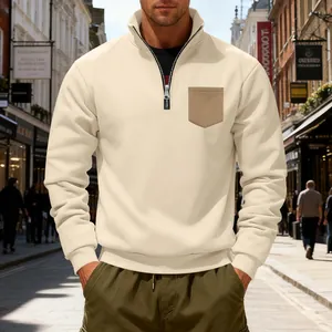 Detail of men's beige quarter-zip sweatshirt with a contrast chest pocket for autumn.