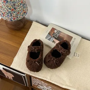 Gros plan sur des chaussures Mary Jane marron duveteuses pour filles avec double nœud élégant
