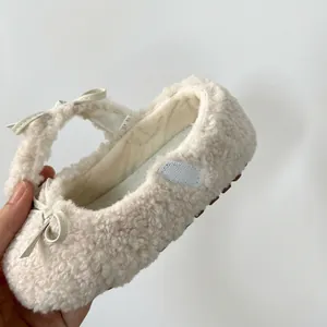 Gros plan de chaussures de princesse en peluche blanche pour filles avec petit nœud.