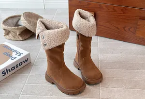 Close-up of girls brown suede boots featuring warm beige fleece lining and fold-over snaps