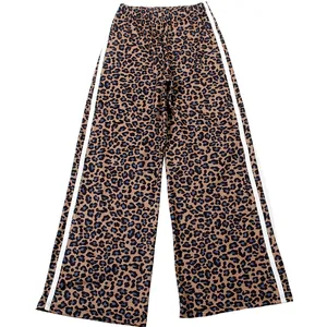 Detailed view of fashionable leopard print wide-leg trousers with white side stripes.
