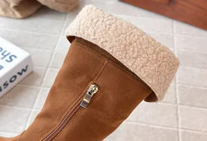 Close-up of brown suede girls' boot with warm fleece lining and side zipper detail