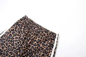 Detailed close-up of leopard print wide-leg trousers showing the elastic waistband
