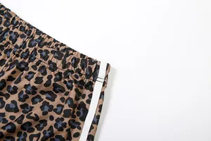 Close-up detail of leopard print trousers with elastic waistband and side stripe