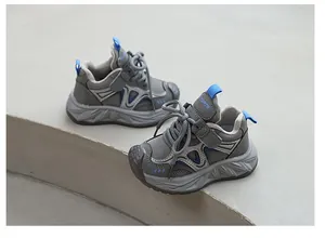 Vue détaillée de baskets épaisses grises respirantes pour enfants avec accents bleus