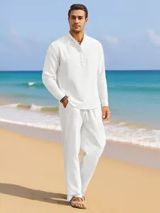 Men's white linen set featuring stand collar shirt and drawstring trousers on beach