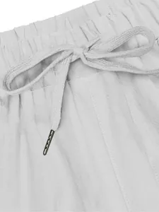 Detail of white linen trousers featuring an elastic waistband with a functional drawstring