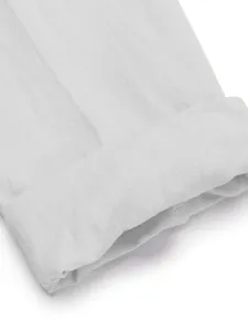 Detailed macro view of white breathable linen shirt trousers set with rolled cuff
