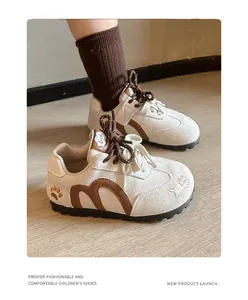 Close-up detail of girls' beige German army trainer sports shoes with brown accents