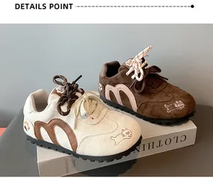 Close-up detail of girls' autumn sneakers featuring cat embroidery and M-logo design