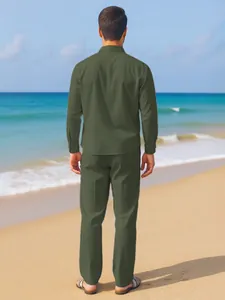 Detail back view of men's olive green linen long sleeve shirt and matching trousers on beach