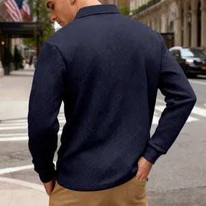 Détail de la texture jacquard bleu marine sur un polo à manches longues épais pour hommes