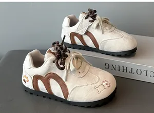 Detail view of retro children's Gump shoes with cute cat embroidery and brown accents.