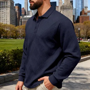 Gros plan d'un polo à manches longues bleu marine avec une maille jacquard diagonale lourde.