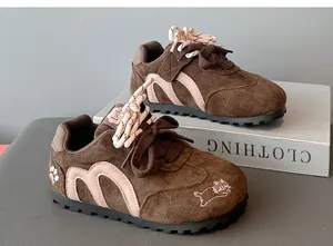 Detailed view of brown suede sneakers for girls featuring cute pink cat embroidery