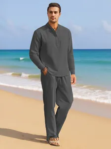 Casual dark grey linen shirt and pants set for men styled on a sunny beach background