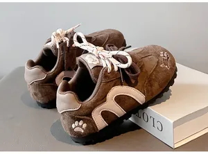 Detailed view of girls' brown suede sneakers with cute dog embroidery and paw detail