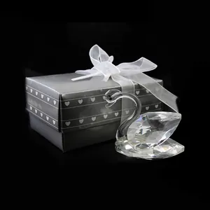 Primer plano de cisne de cristal tallado con caja de regalo gris decorada con corazones