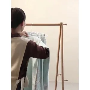 Space-saving spiral drying rack for bed sheets and blankets on a wooden rack.