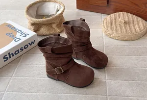 Détail des bottines plissées en daim marron pour filles avec boucle décorative