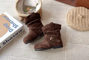 Gros plan de bottes en daim marron pour filles avec boucle rétro et design plissé chic