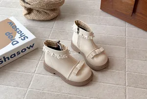 Gros plan de bottines beiges pour filles avec dentelle de perles et détails de nœud