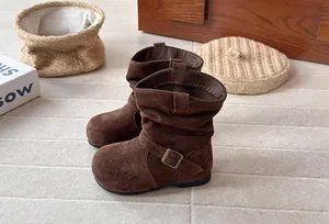 Vue latérale de bottes plissées en daim marron pour filles avec boucle décorative