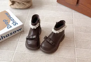 Vue détaillée des bottines d'hiver marron pour filles avec nœuds et dentelle.