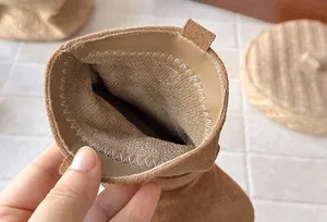 Détail de la doublure intérieure douce et des surpiqûres de bottes en daim pour fille.