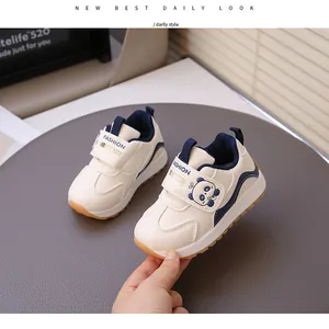 Close-up view of toddlers' cream sneakers with a cute panda cartoon and velcro strap